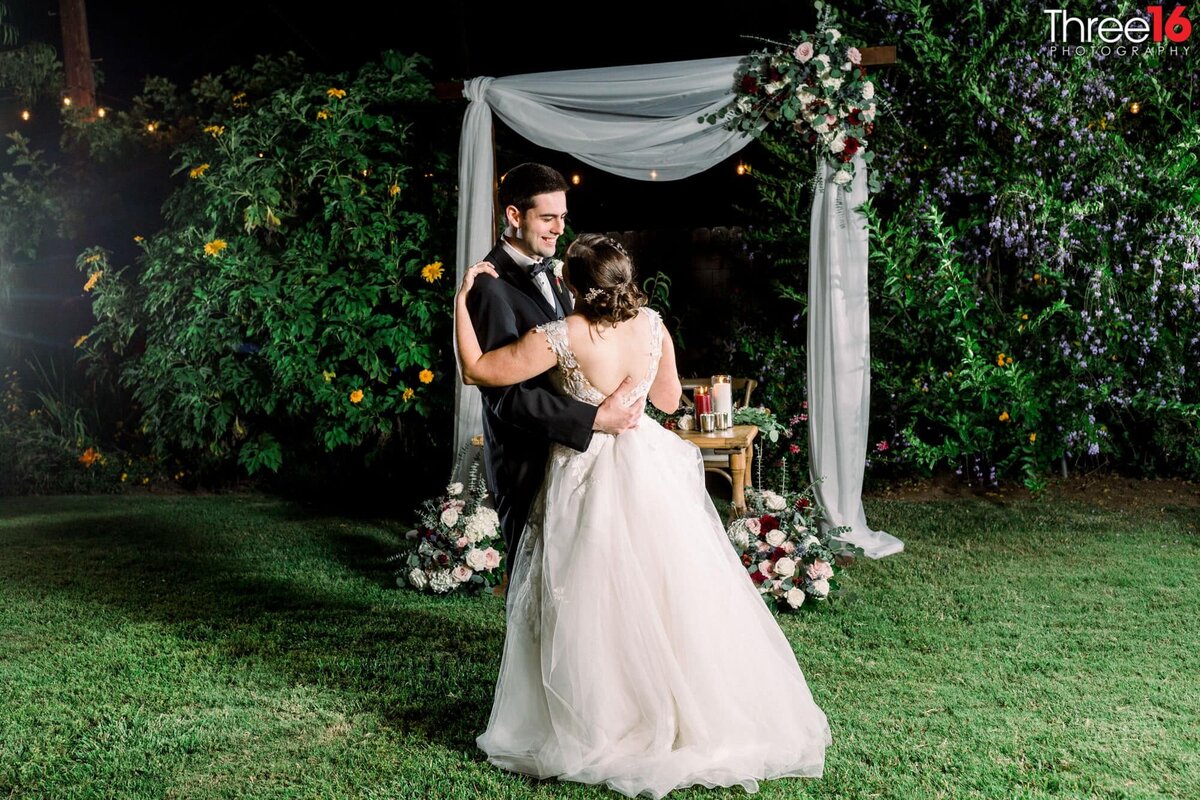 Bride and Groom embrace each other at night during a wedding photo shoot