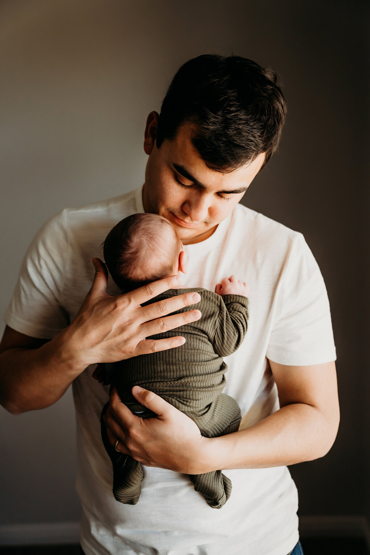 Newborn Photographer, a young dad admires his baby
