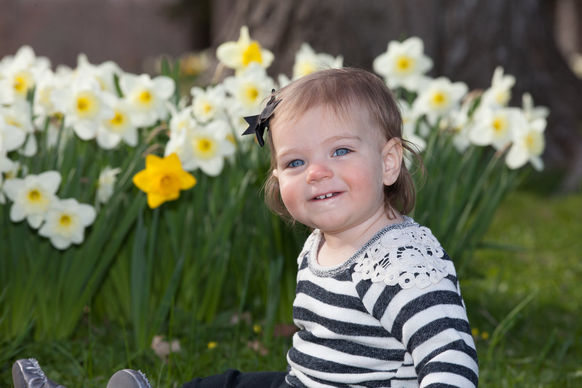 little girl in front of daffodils