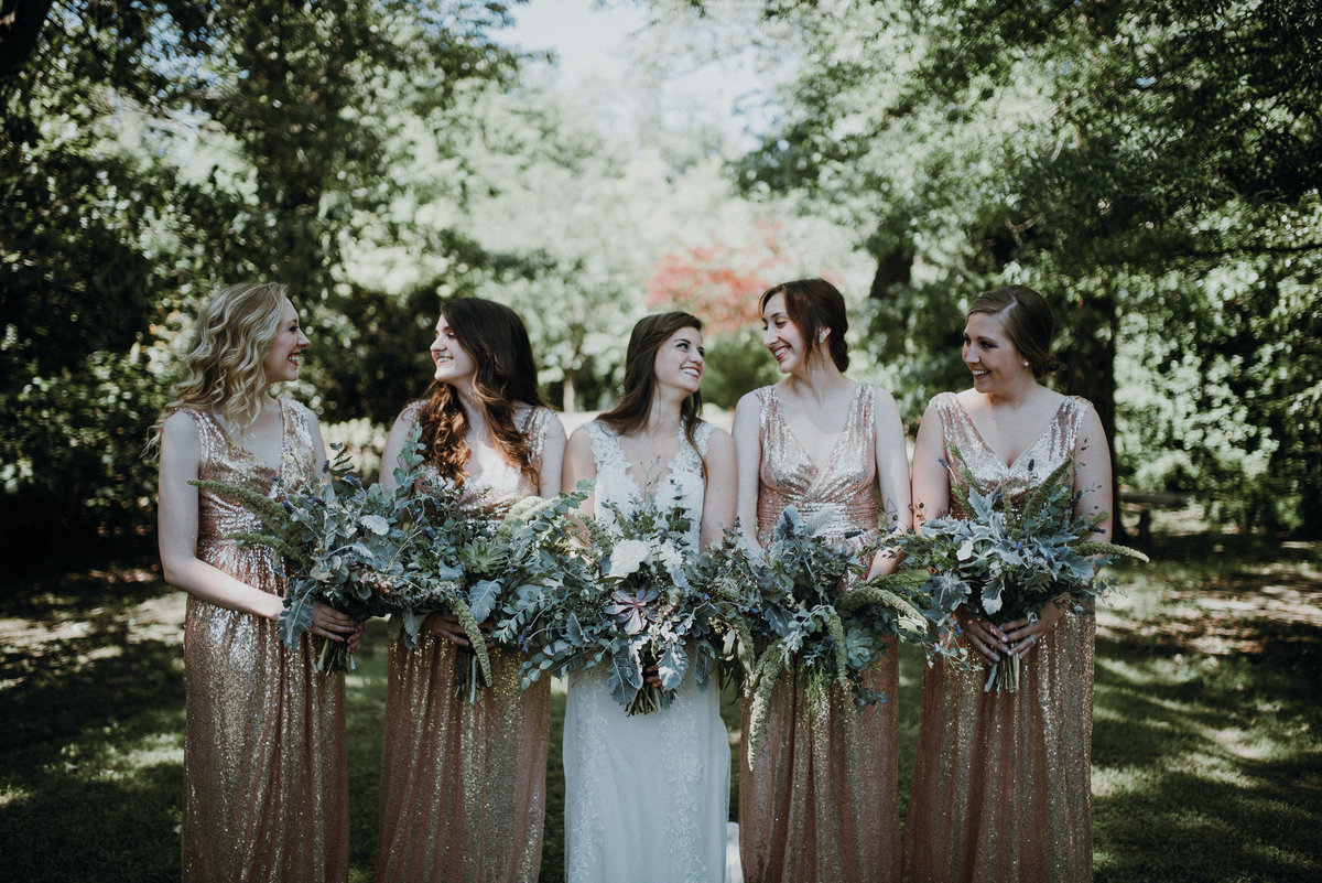 Bride and her bridesmaids laughing before their gorgeous estate wedding in Arkansas
