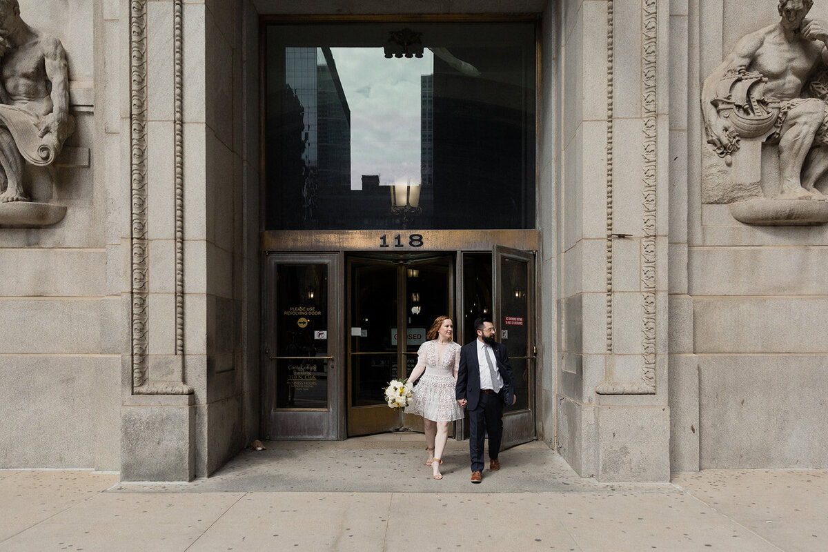 couple walks out of city hall after their wedding ceremony