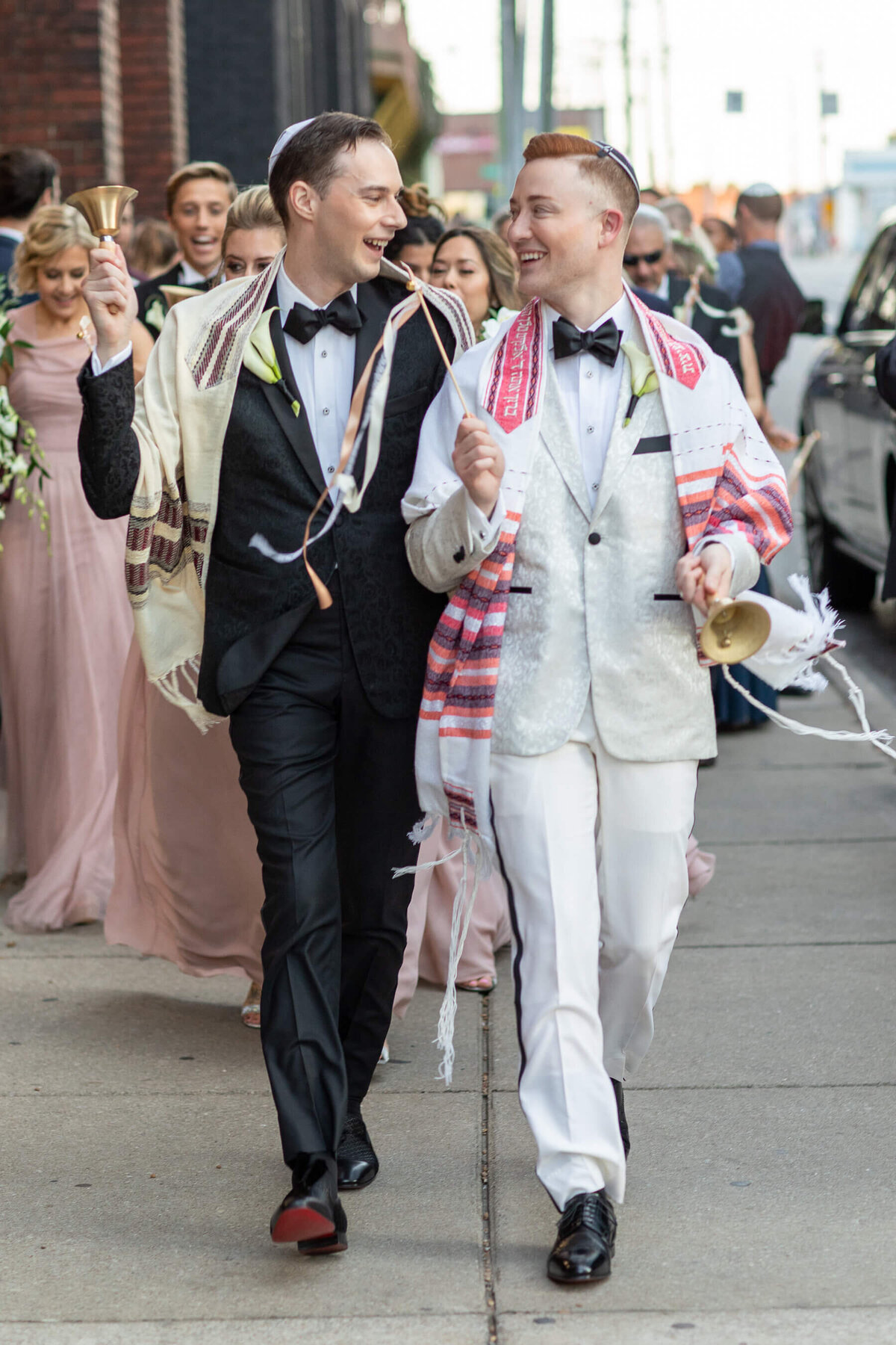 Black and white custom tuxedos on grooms at Jewish wedding ceremony