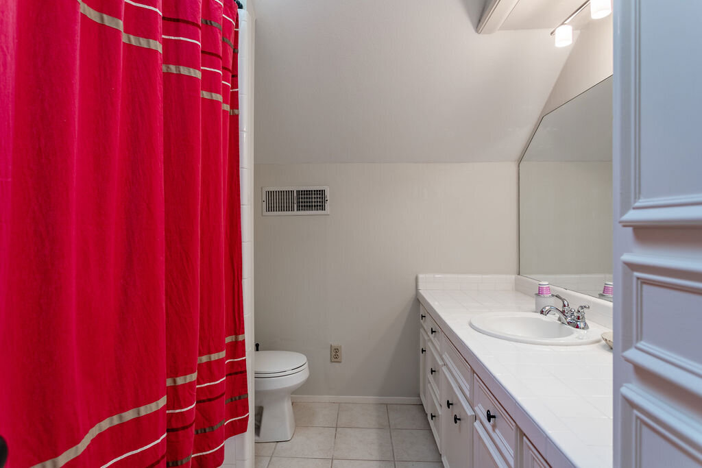 Bathroom with large vanity and shower in this 5-bedroom, 4-bathroom vacation rental house for 16+ guests with pool, free wifi, guesthouse and game room just 20 minutes away from downtown Waco, TX.