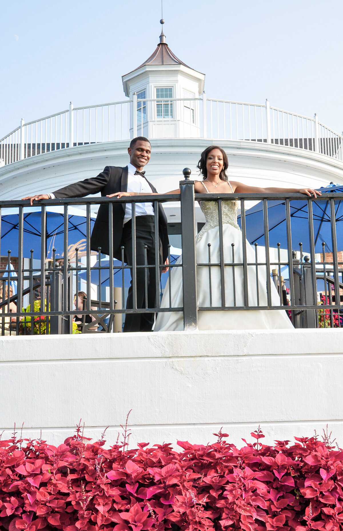 Elegant wedding venue that has beautiful florals and bride and groom standing in the railings