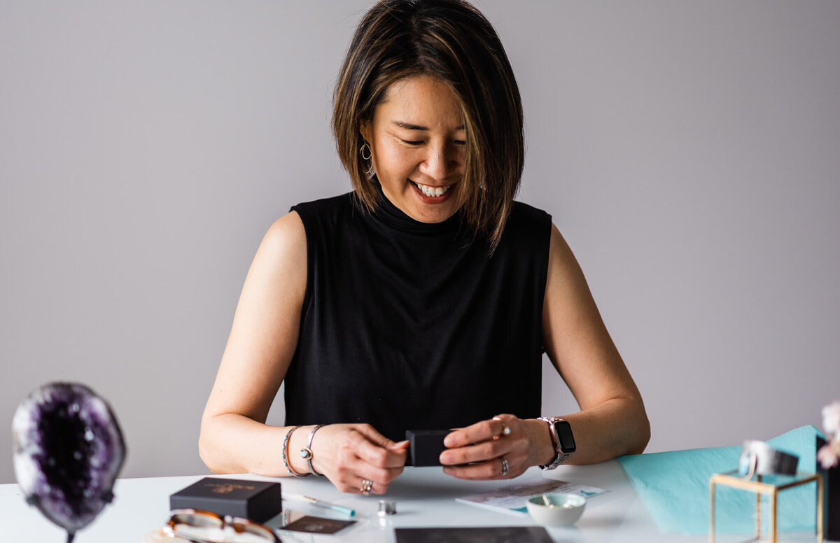 jeweler smiling while packing up earrings during her branding session