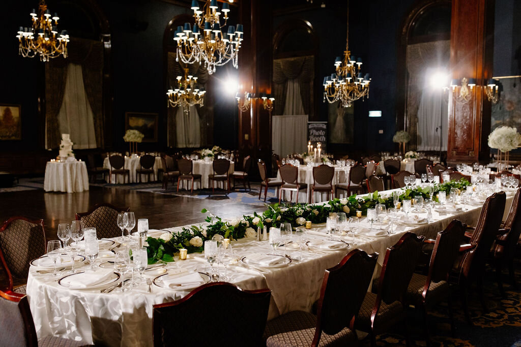 Union League Club of Chicago ballroom with elegant chandeliers and timeless white rose and greenery centerpieces.