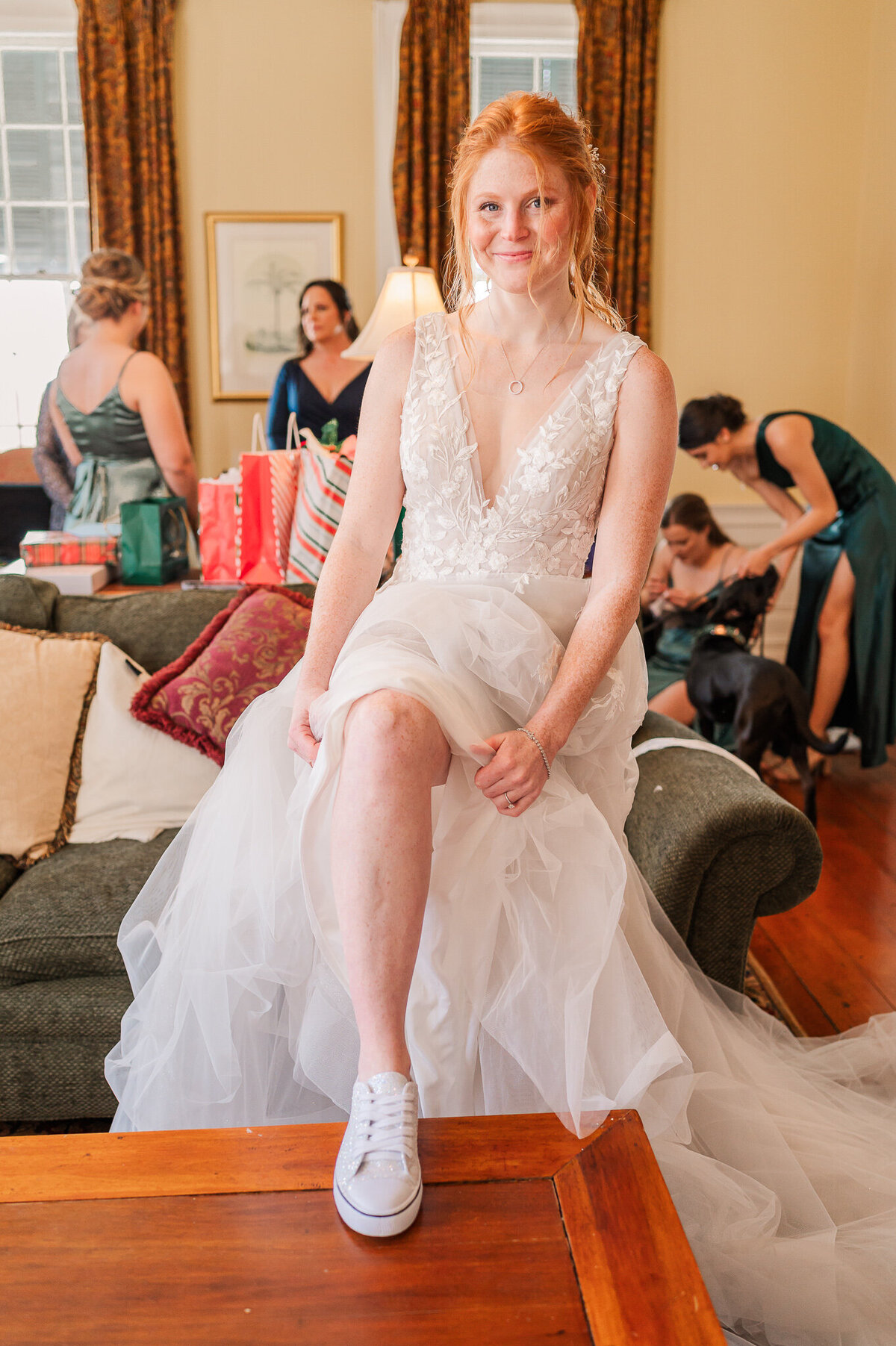 A bride getting ready on her wedding day showing off a pair of custom shoes enjoying her North Carolina wedding photography