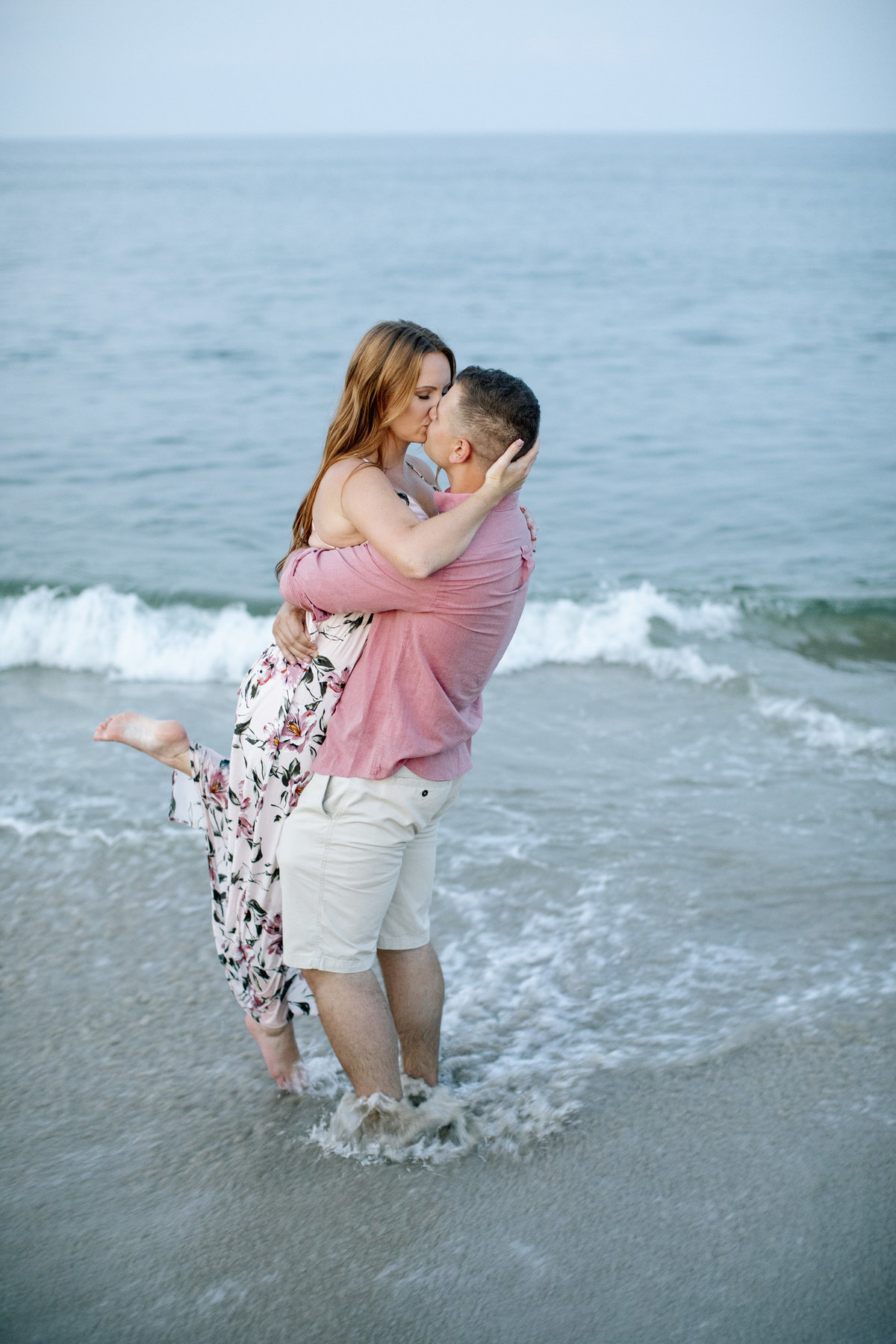 engaged couple kissing by ocean at manasquan beach