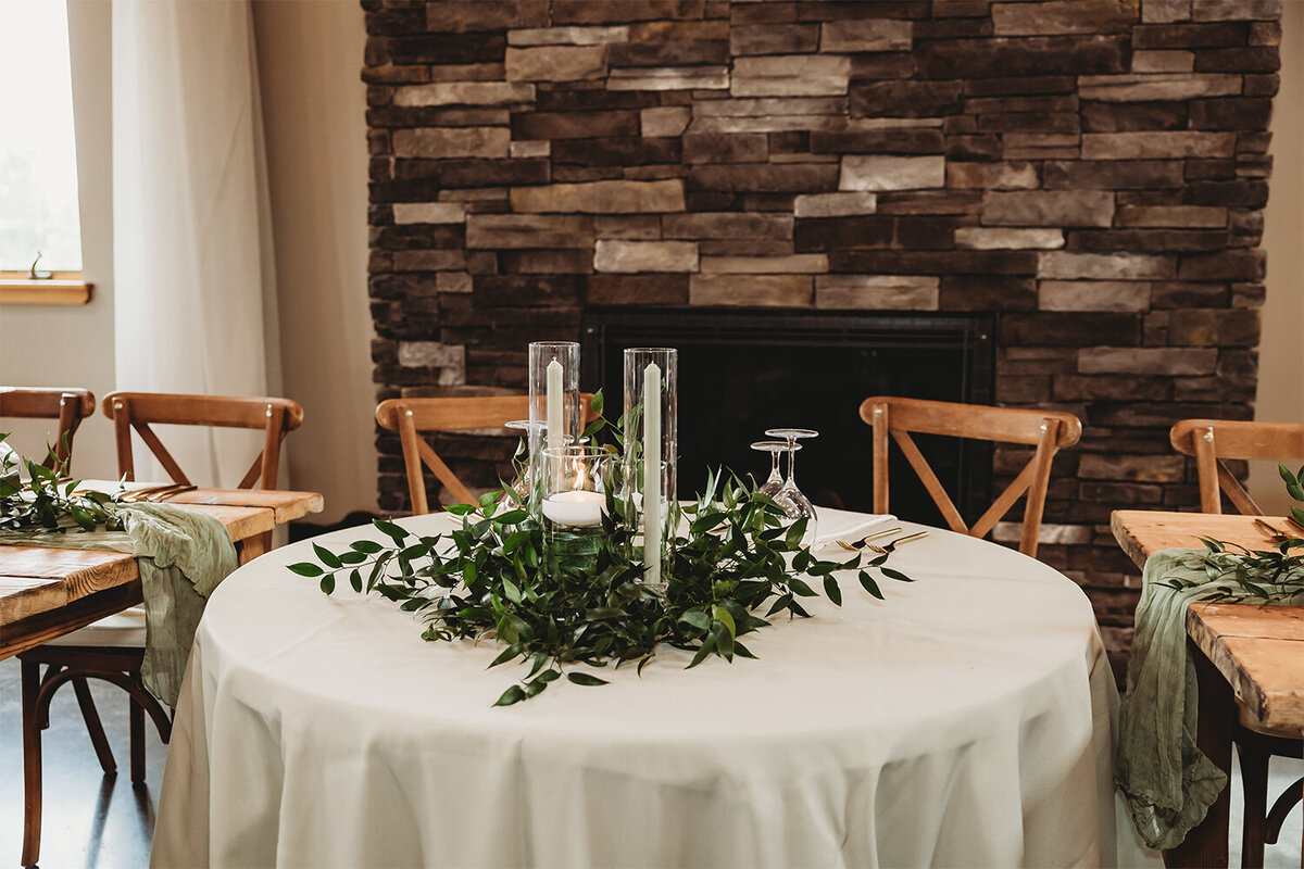 Sweetheart table with candles and greenery for mountain sage wedding at Camelot Ranch.