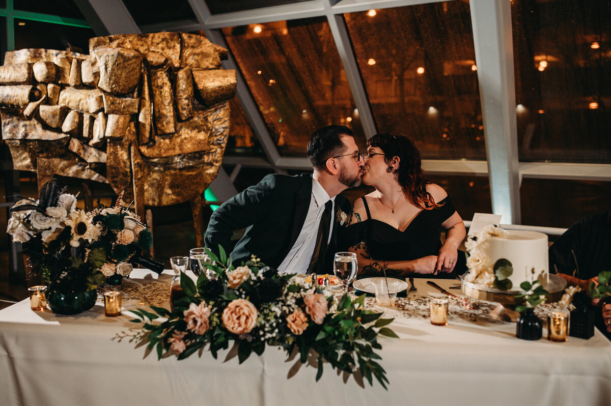 Wedding couple kiss at head table, photo by ohio wedding photographer