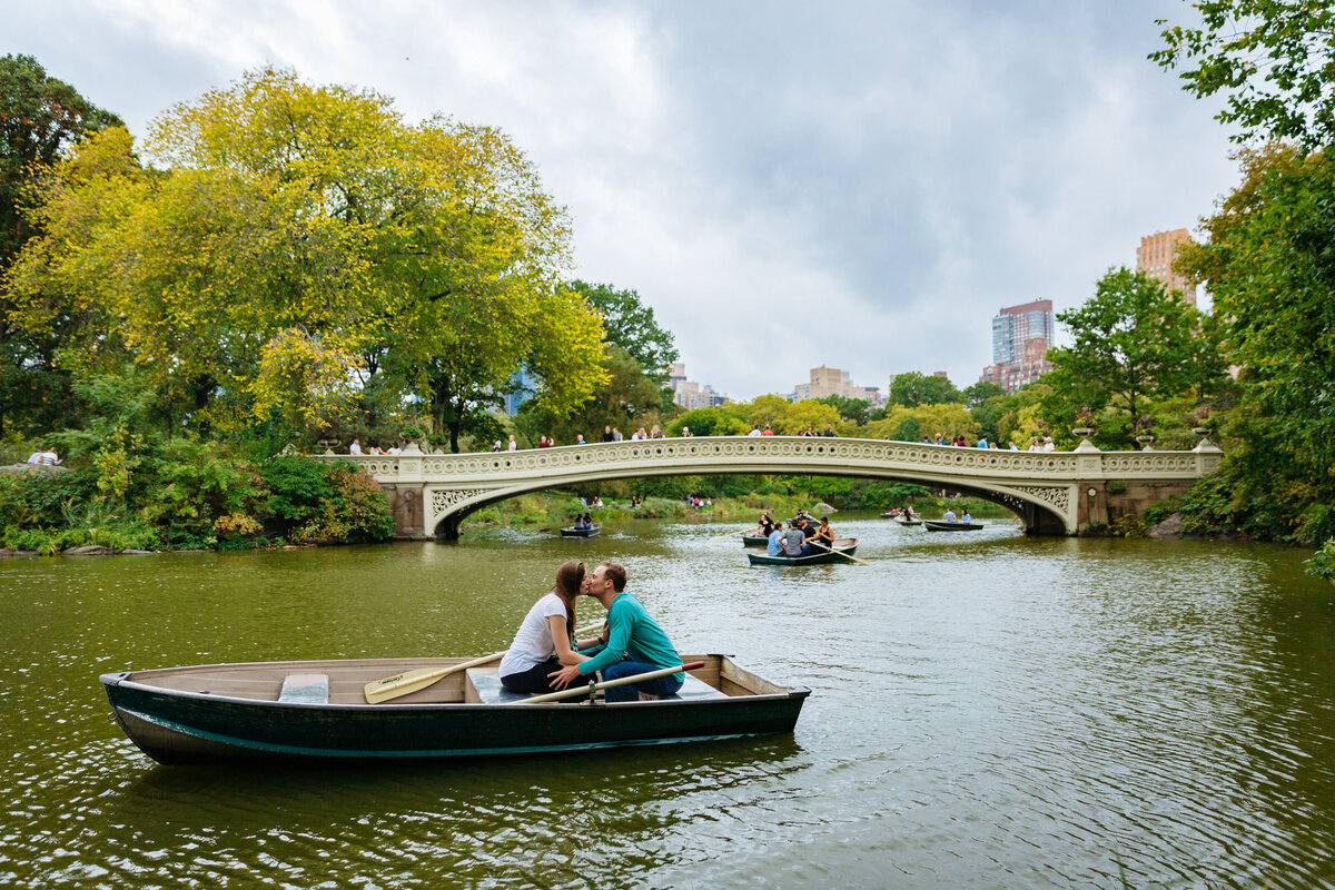 A couple kissing in a small row boat.