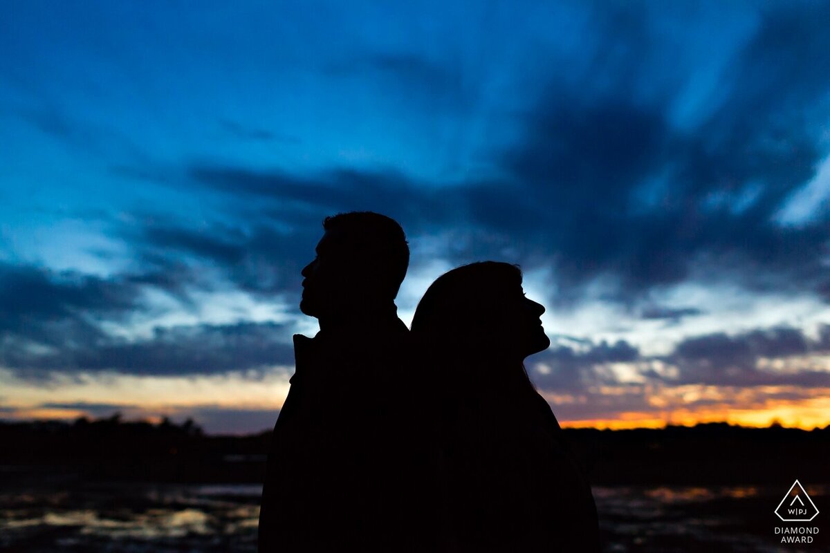 Portsmouth New Hampshire Engagement Session with the couple silhouetted against the sunsetting sky