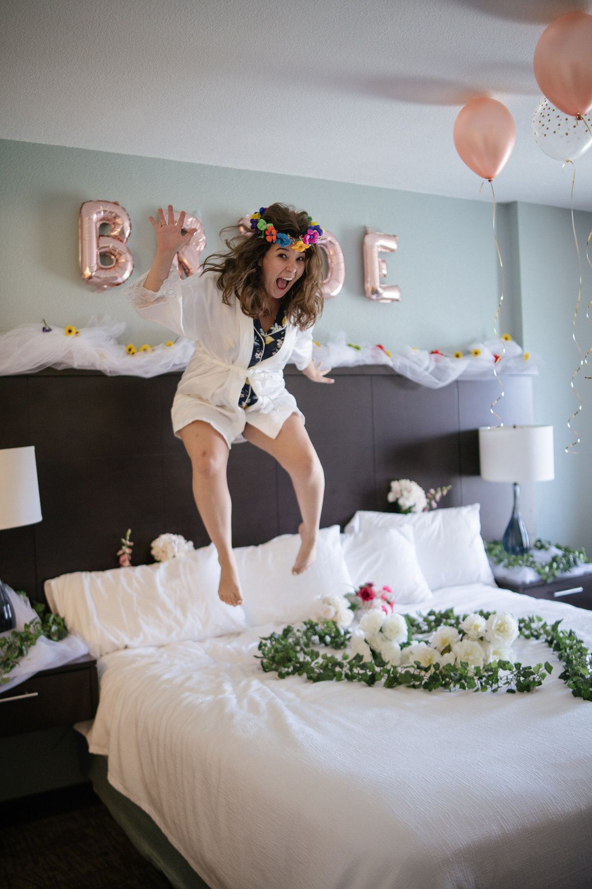 Bride jumping on bed while getting ready for wedding ceremony in downtown San Antonio