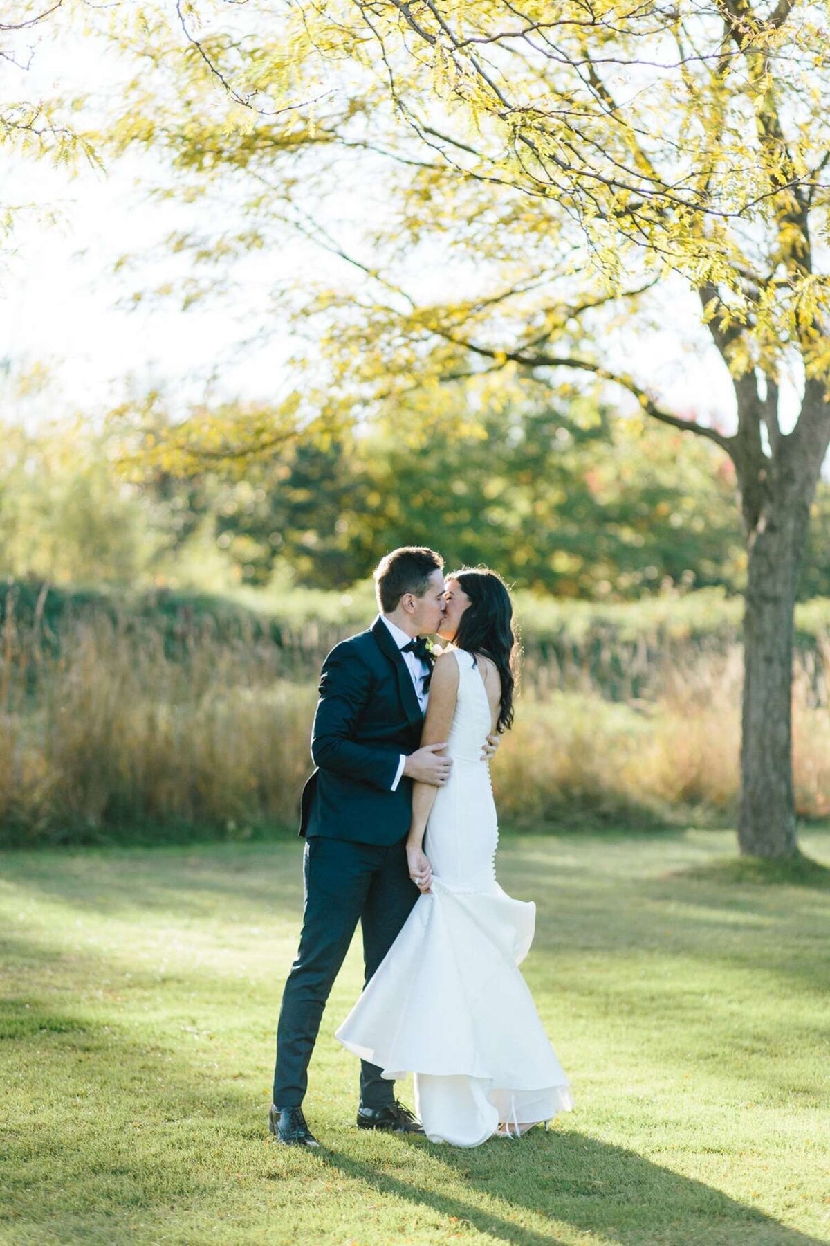 Classic and elegant bride and groom take portraits at a luxury Michigan lakefront golf club wedding.