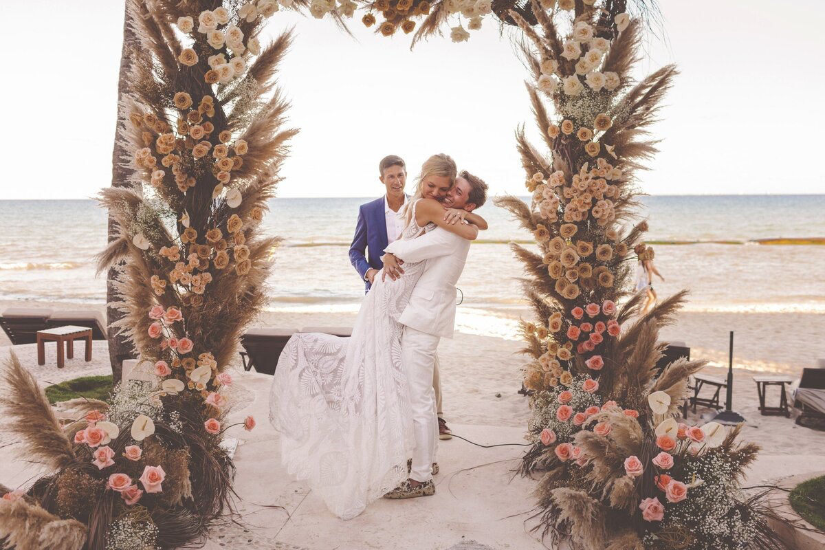 Bride and groom hug after kissing at wedding in Riviera Maya