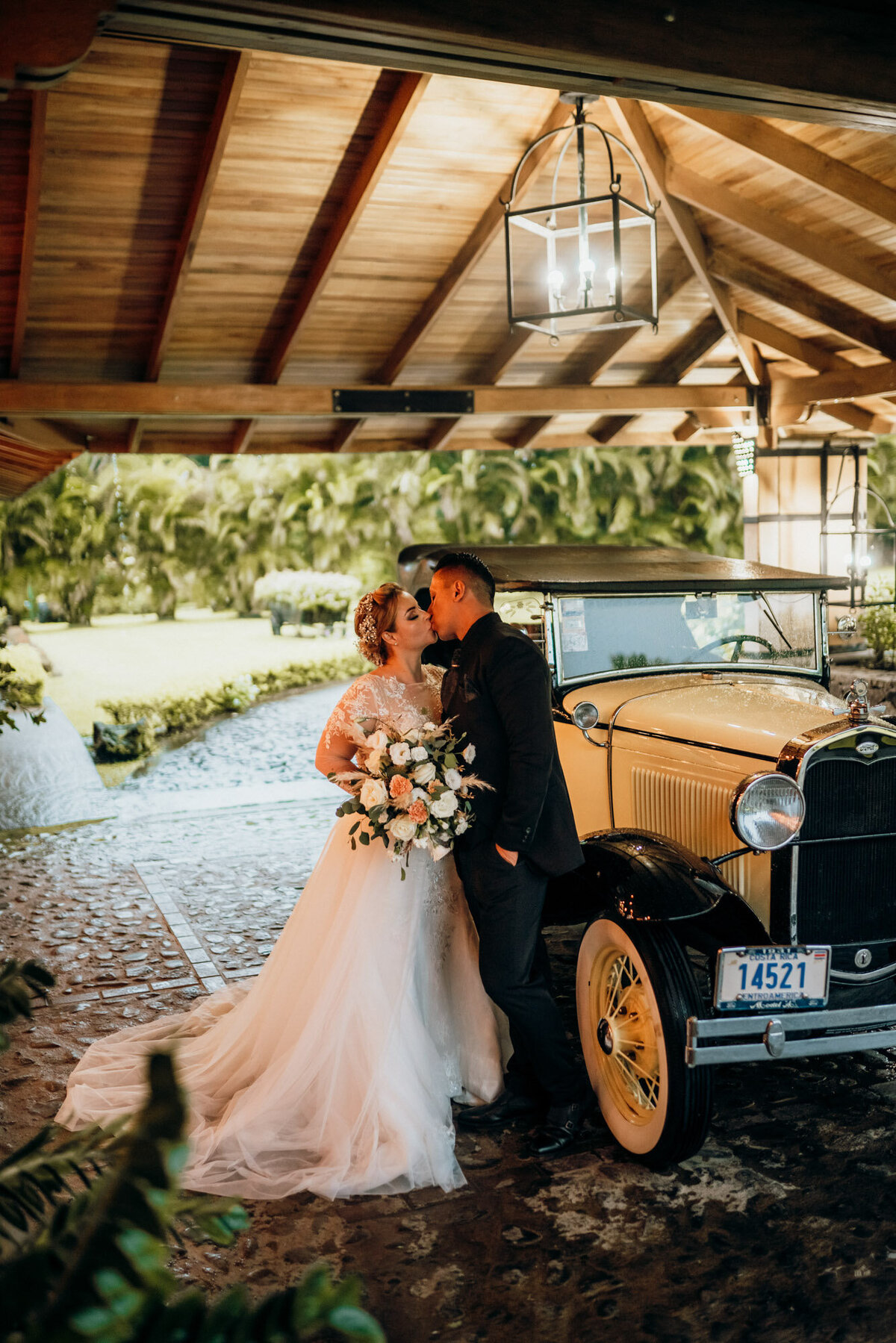 couple kissing next to old car