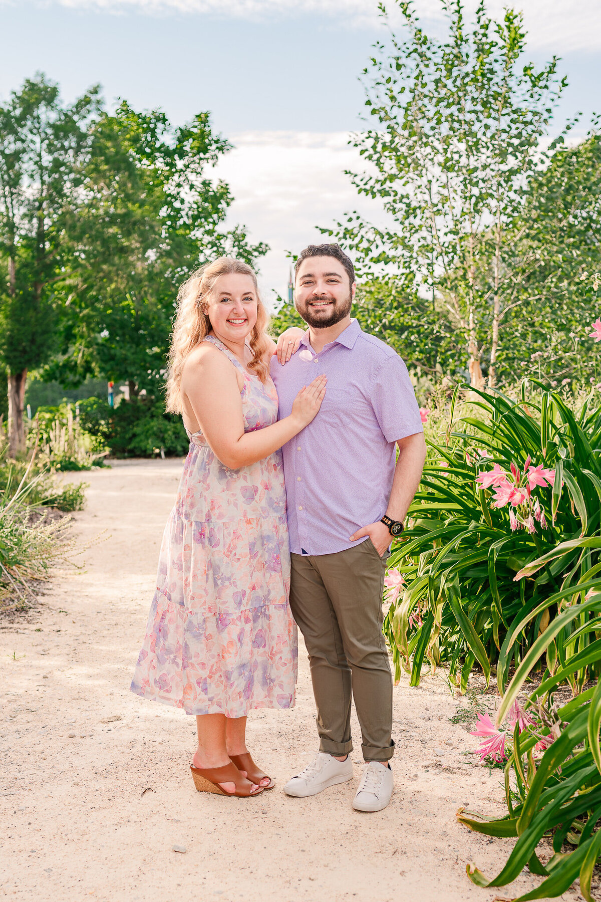 An engaged couple cozy together in The Arboretum enjoying their Raleigh wedding photos
