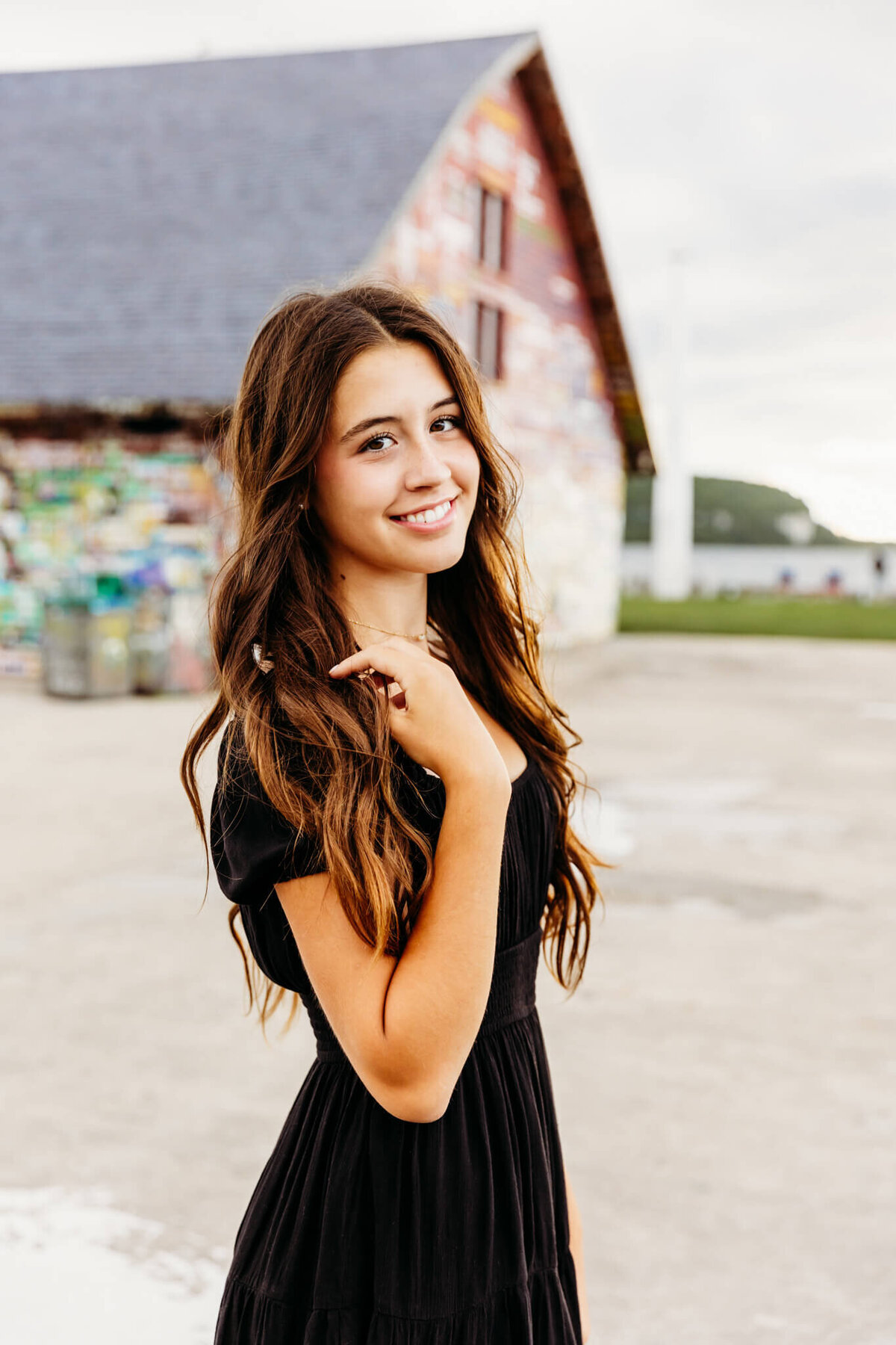 image of a brown haired teen touching her shoulder  by Green Bay senior photographer Ashley Kalbus