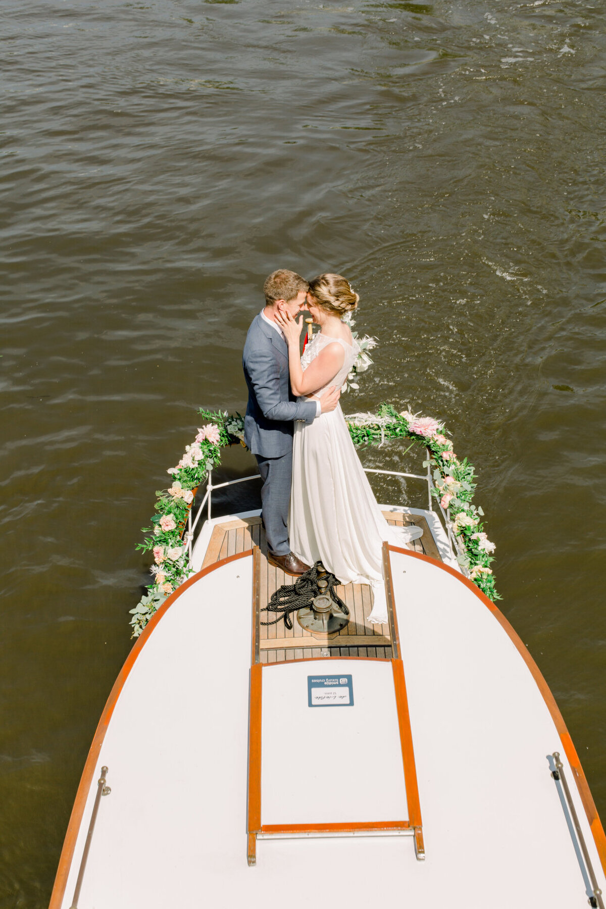 Wedding couple on a canal boat tour in Amsterdam for a photo shoot organized by Lovely & Planned