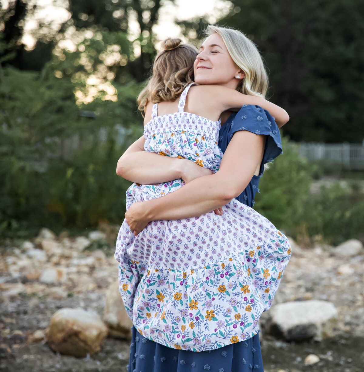 A Towson, Maryland mother cuddles and hugs her daughter during their lifestyle family session on the river.