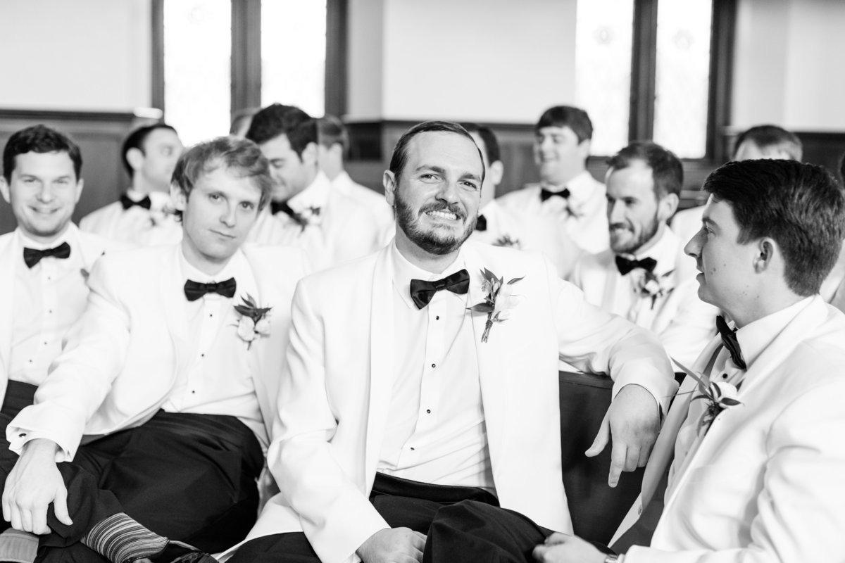 groomsmen in white dinner jackets sitting in church