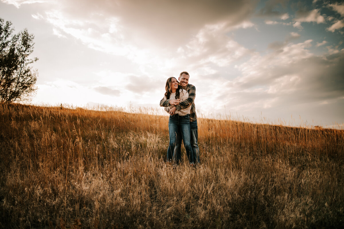colorado hold eachother on grassy hill in thornton colorado for family session