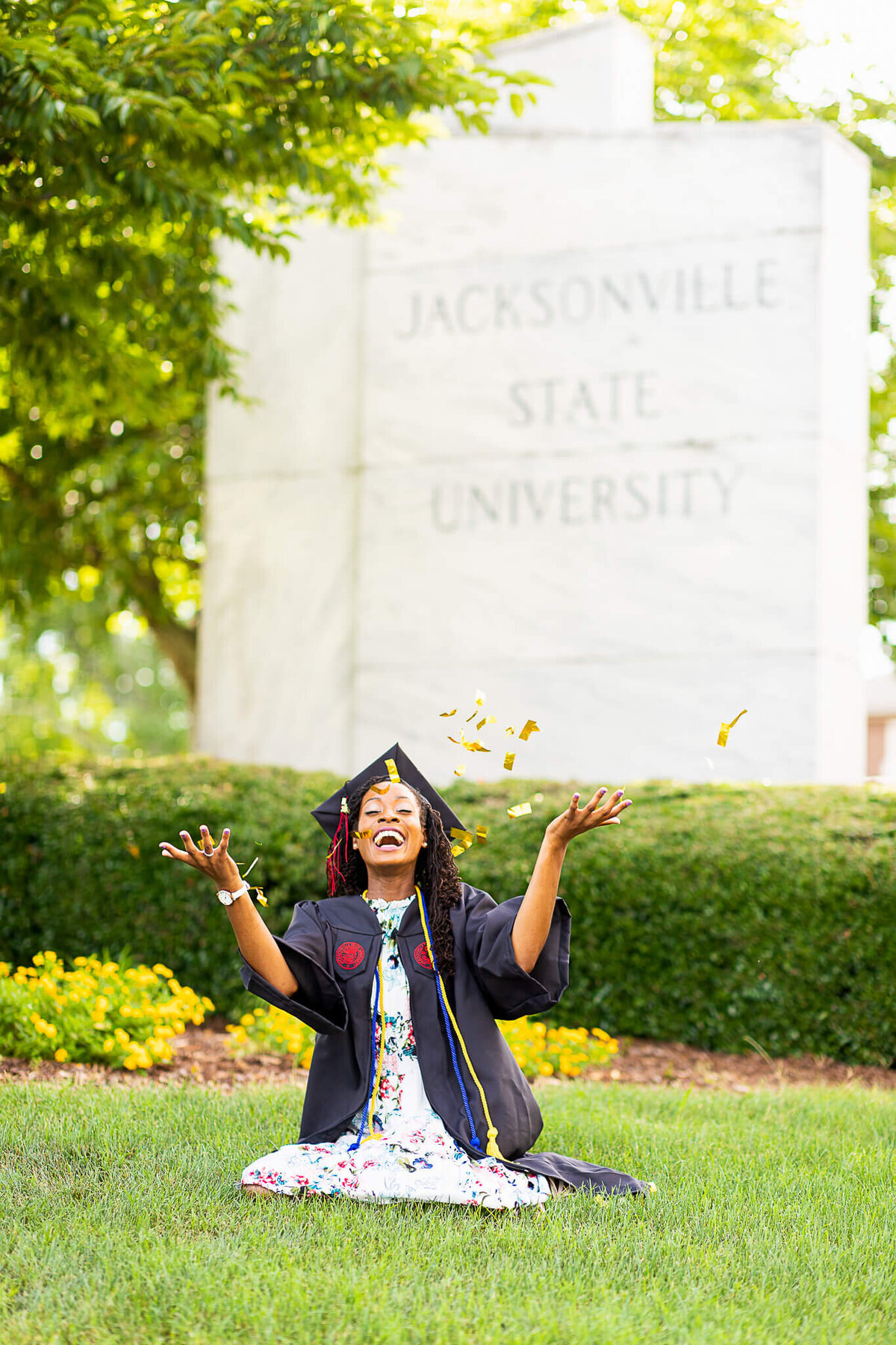 College graduate celebrates with confetti in front of her college
