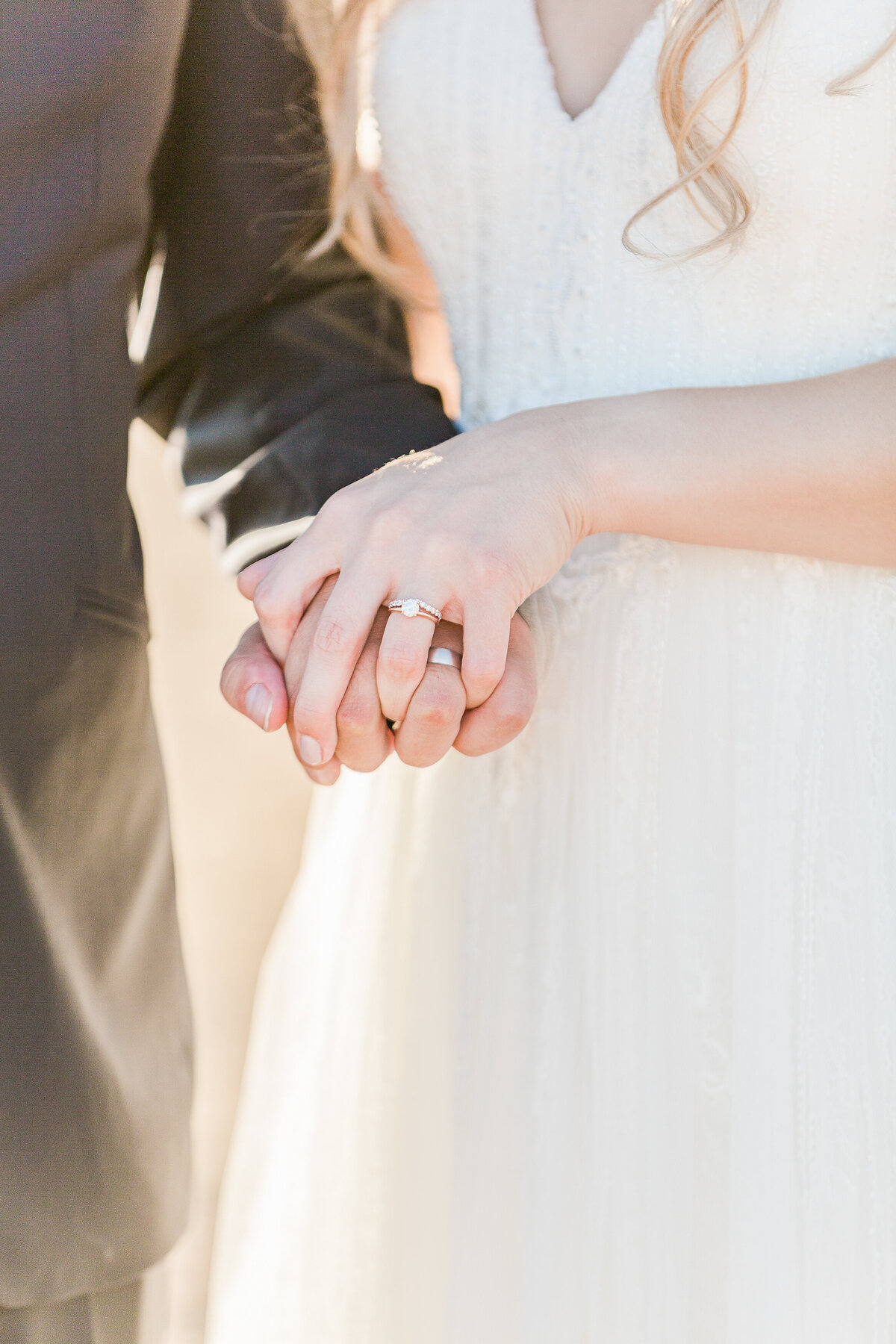 Detail image. Bride and groom are holding hands and featuring their wedding rings. Captured by best New England wedding photographer Lia Rose Weddings.