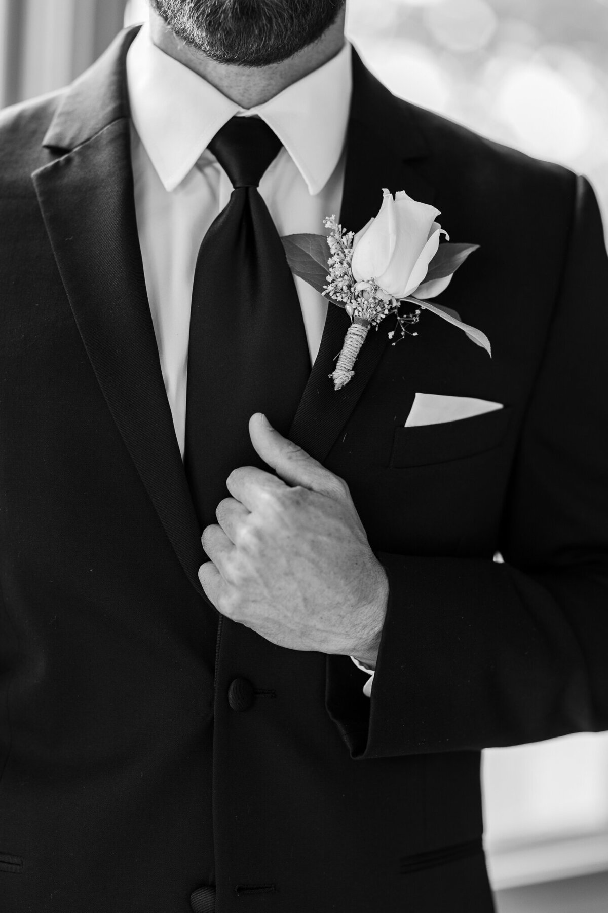 groom holding onto jacket on wedding day in montrose co