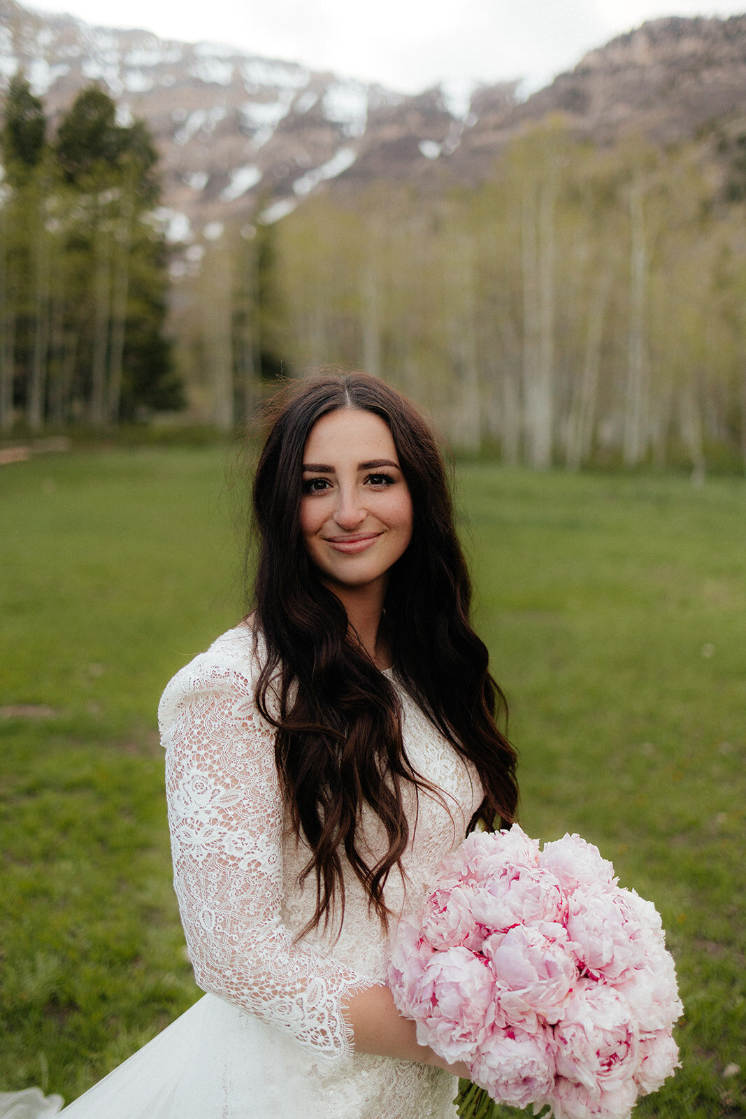 Bridal photography with lace wedding dress and pink peony bouquet.