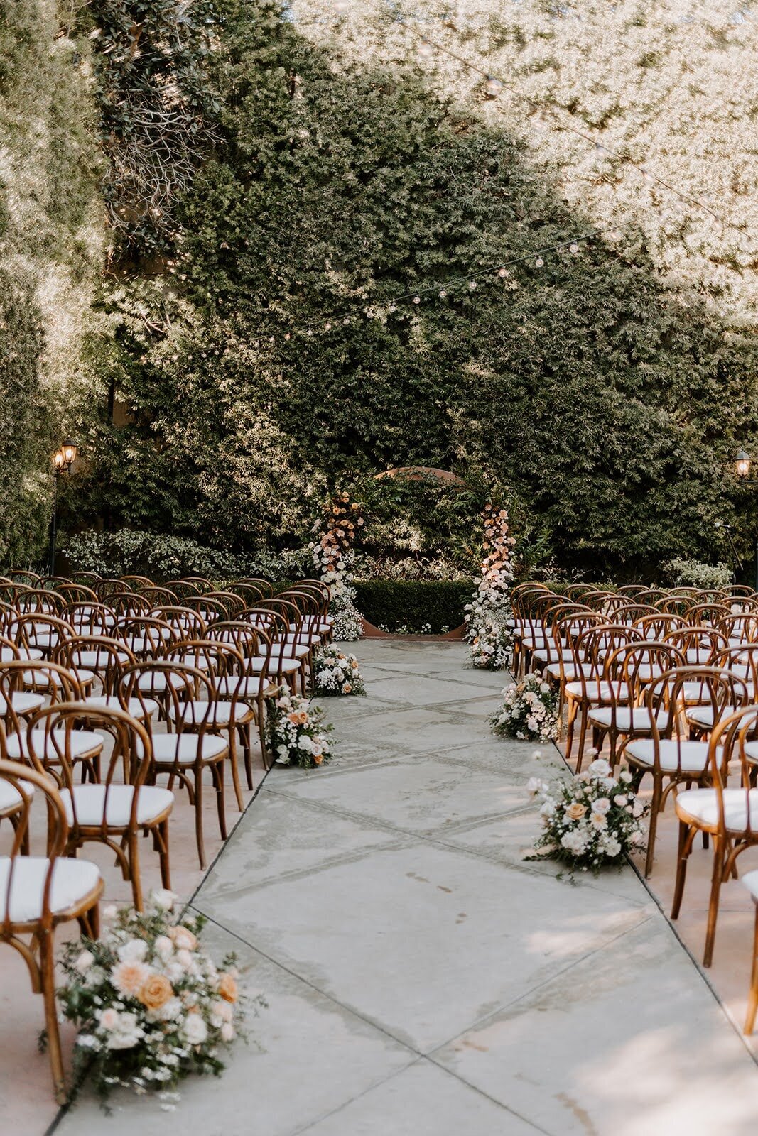 Lush florals on a circle arch with aisle florals at Franciscan Gardens