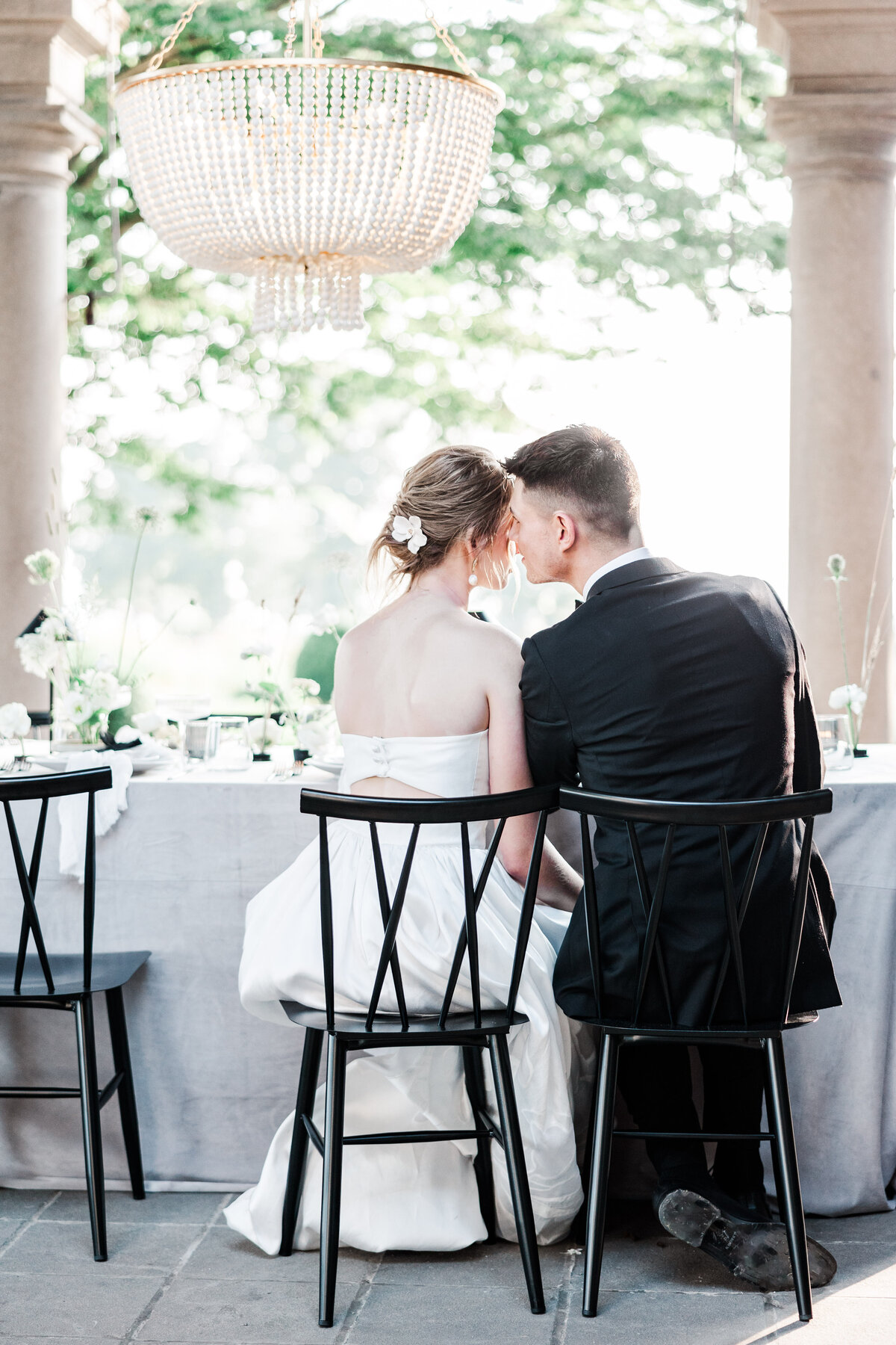 bride and groom touching foreheads while sitting at reception