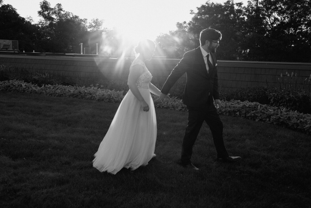 black and white photo of bride and groom with dramatic sun flare