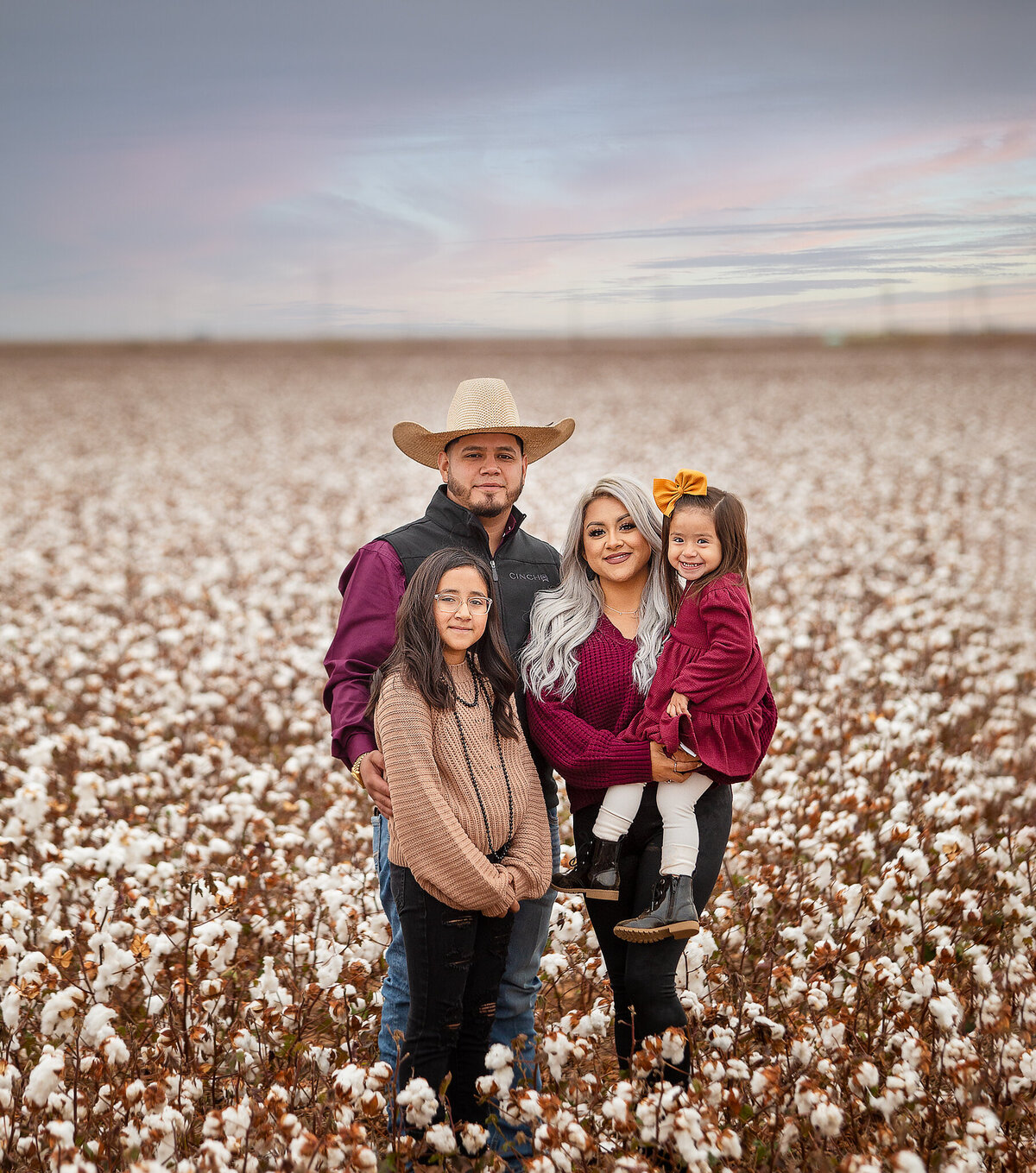 Family standing in cotton fields