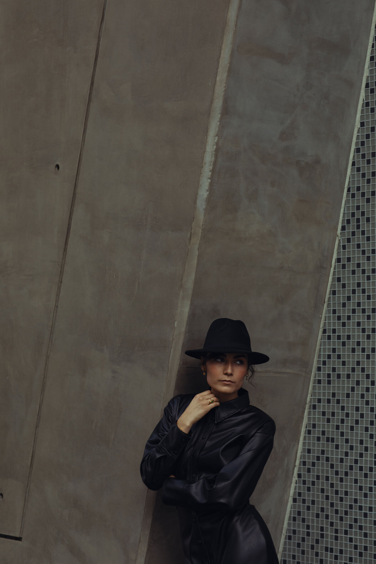 Portrait Photo Of Young Woman In Black Hat Leaning Against a Wall Los Angeles