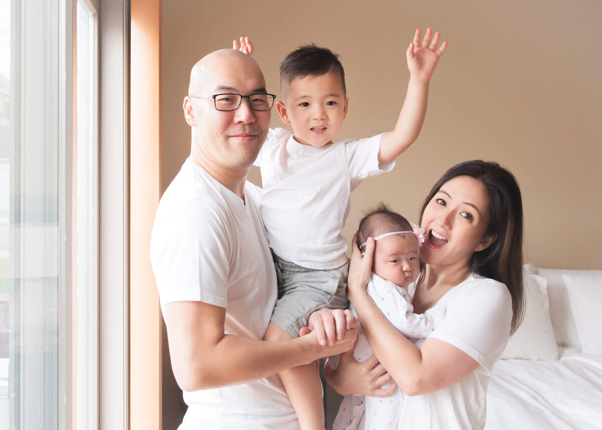 sweet family with little boy excited putting his arms up when mom says yaaay