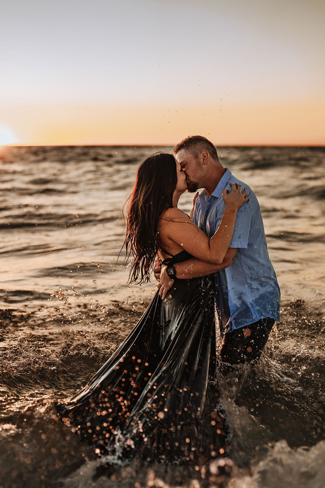 couple in the water during engagement photos at coquina beach