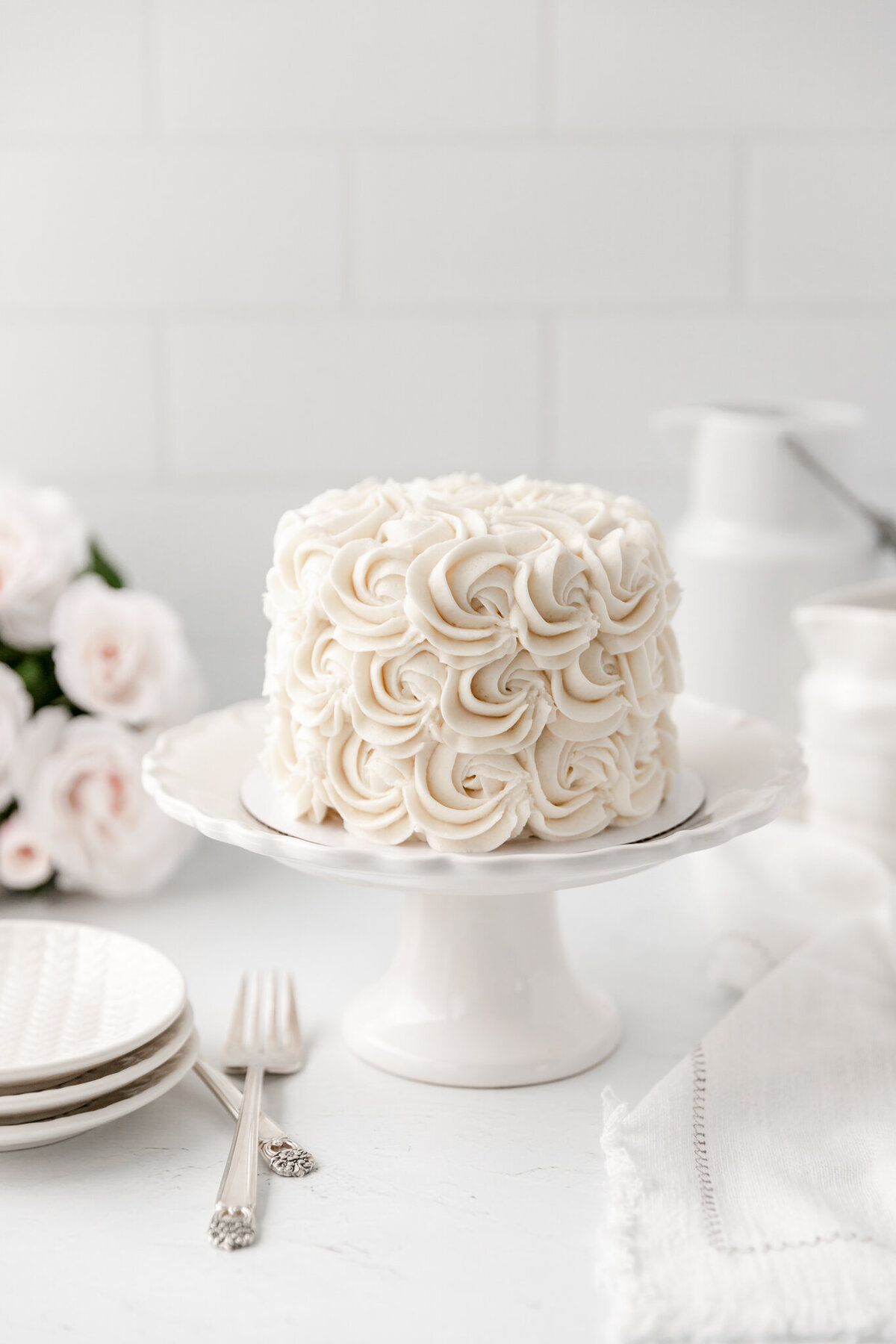 a cake decorated with a white rose frosting design
