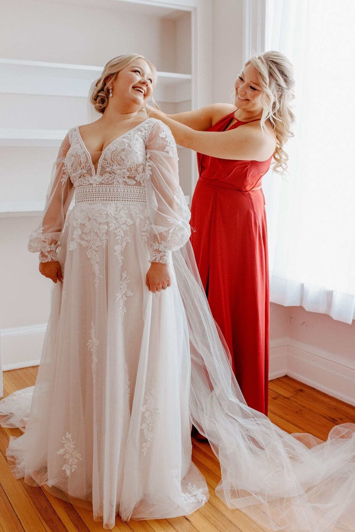12-kara-loryn-photography-bridesmaid-helping-bride-with-wedding-dress