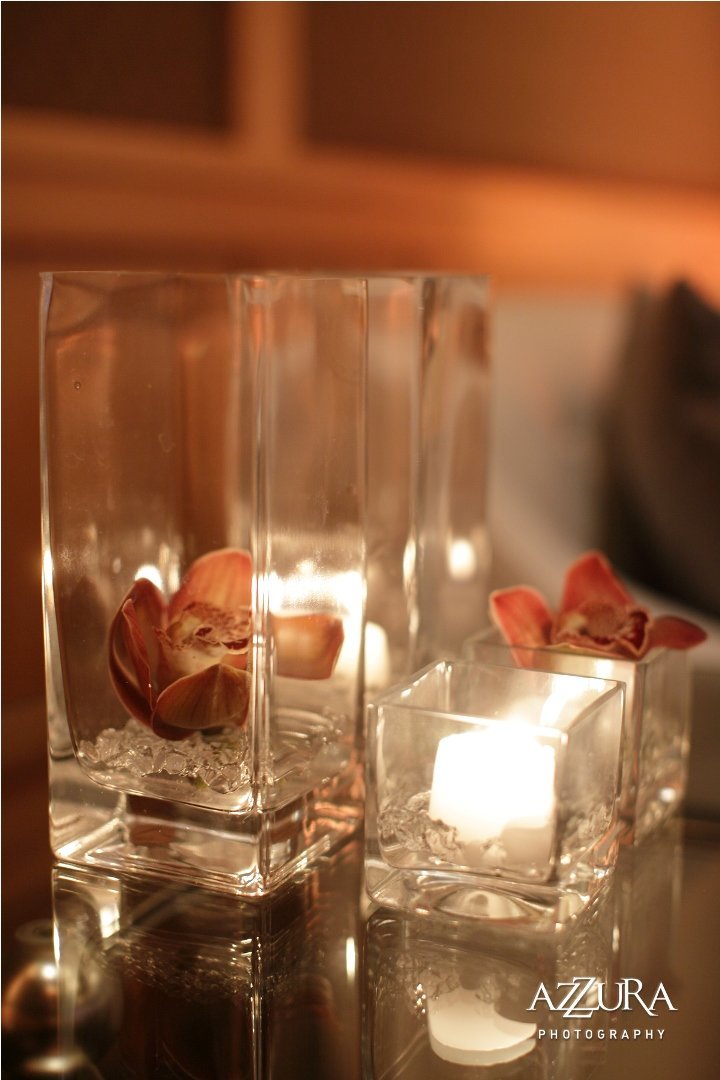 grouping of square hurricane candles  with submerged brown orchids