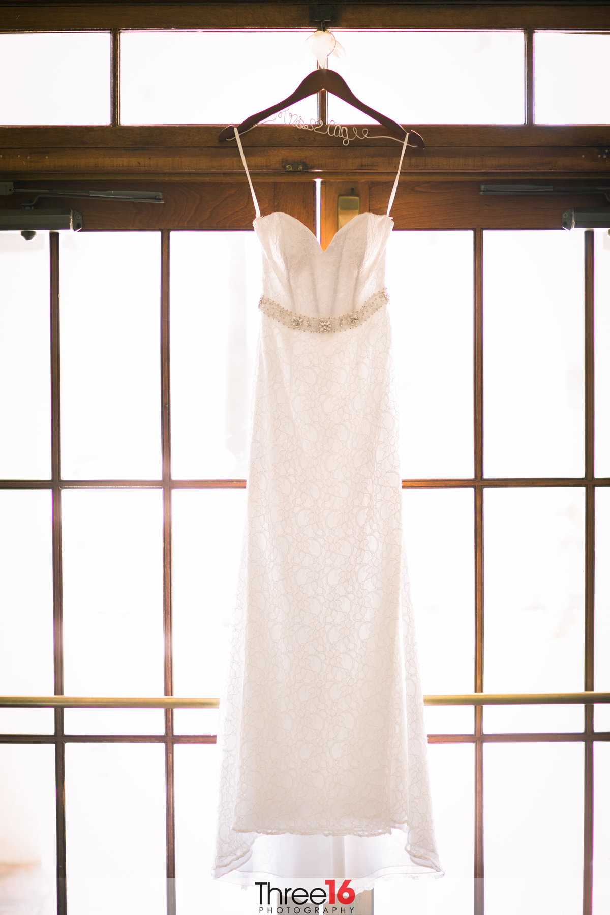 Brides dress hanging from a window