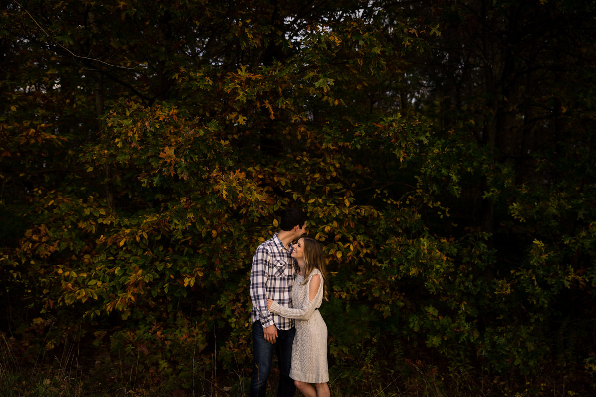 Fall trees and kisses fill this image at the The Preserve at Chocorua NH engagement session