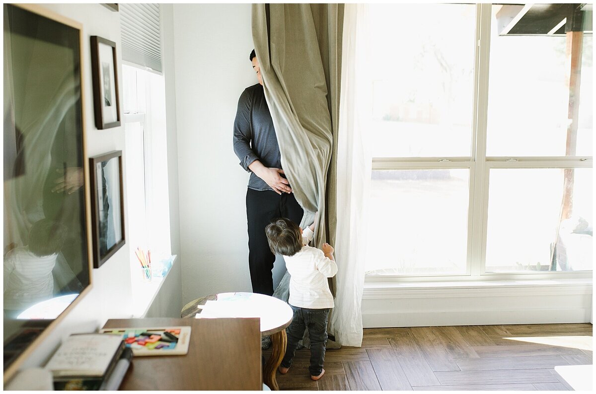 Man hiding behind curtain whilst boy uncovers him at family photo session in Austin by Amber Vickey Photography
