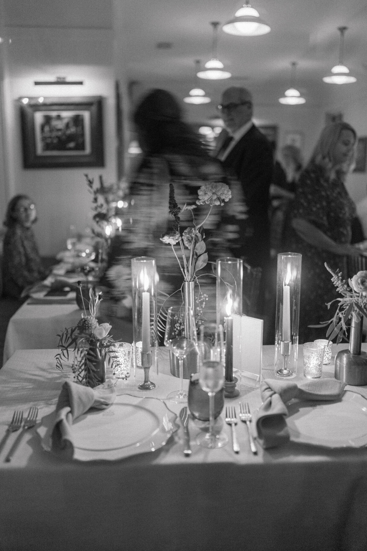 Guests find their seats at intimate candlelight dinner at the Post House Inn. Black and white wedding photos. Kailee DiMeglio Photography.