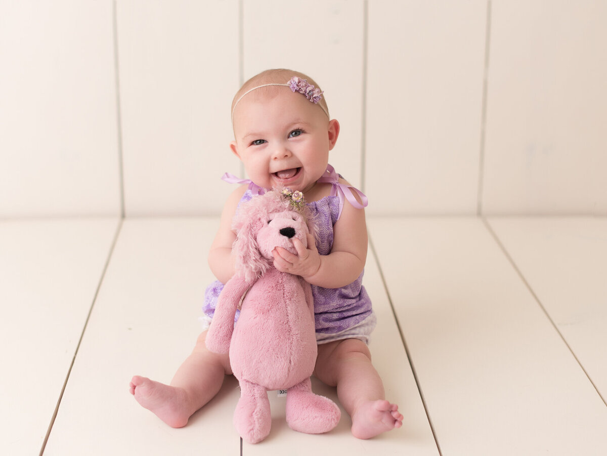 Smiling baby in a purple dress  portrait by Laura King, Houston photographer