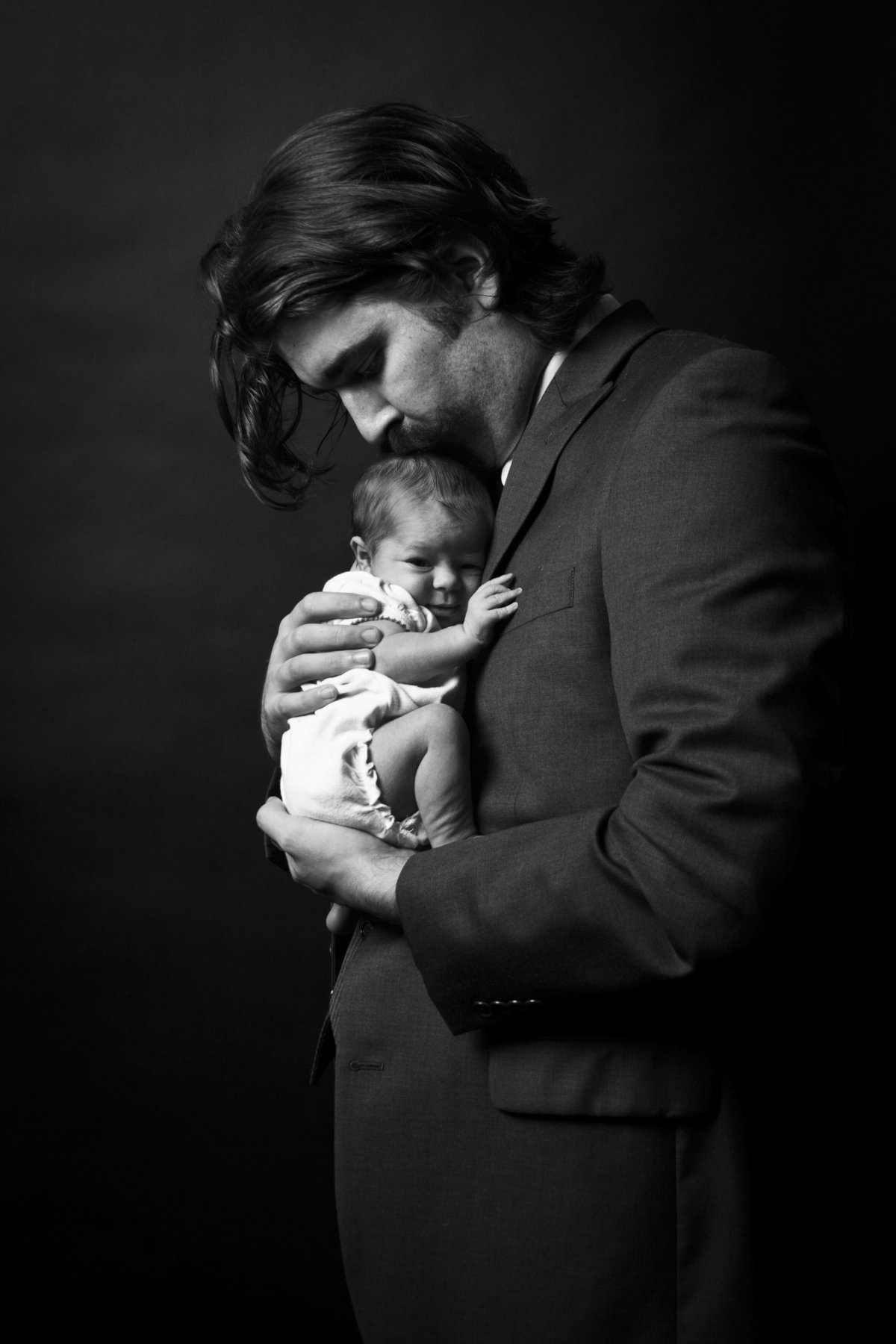 Father holding his newborn baby for and in home newborn photography session.