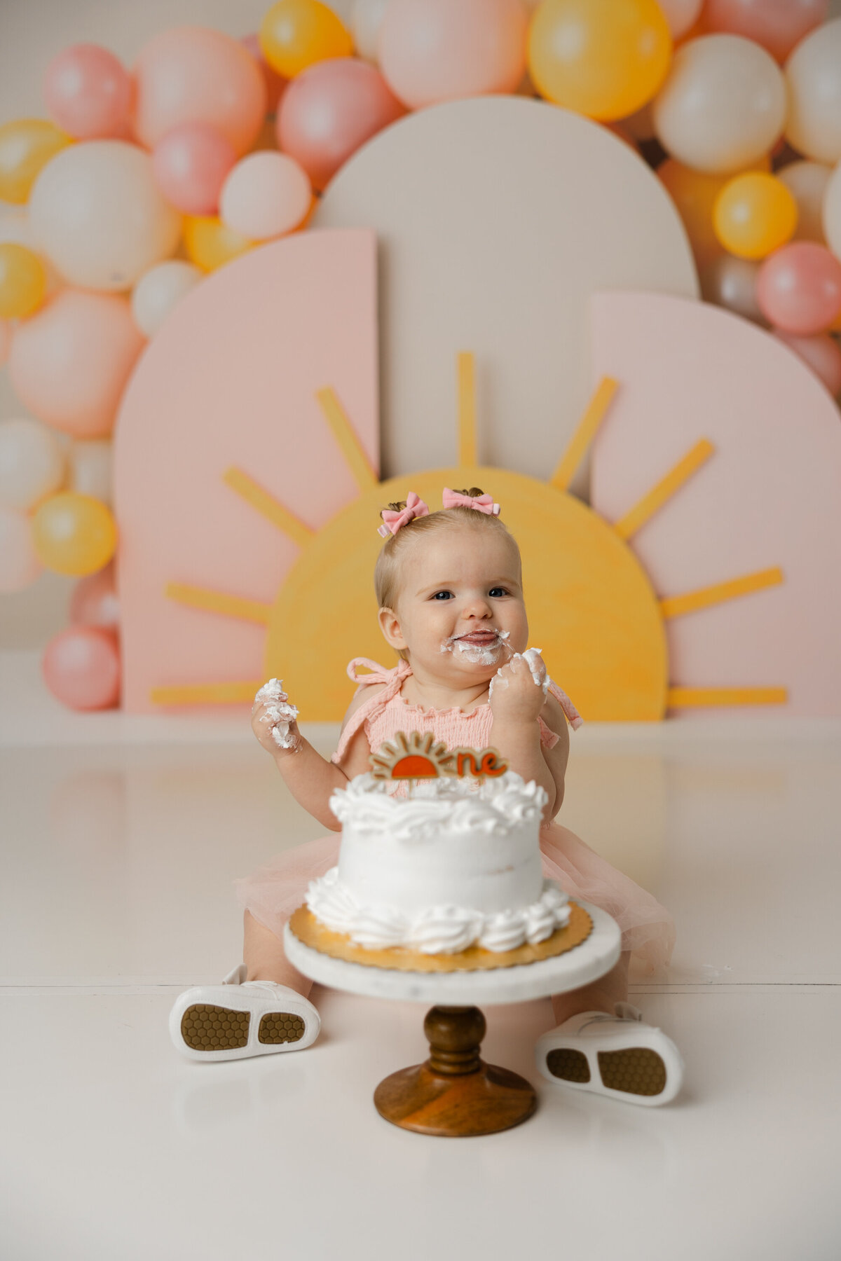 Frosting on her face, joy in her eyes, and sunshine all around! Celebrating one sweet year with this happy little girl. Yucaipa cake smash photographer Kaitlyn Dawn Photography.