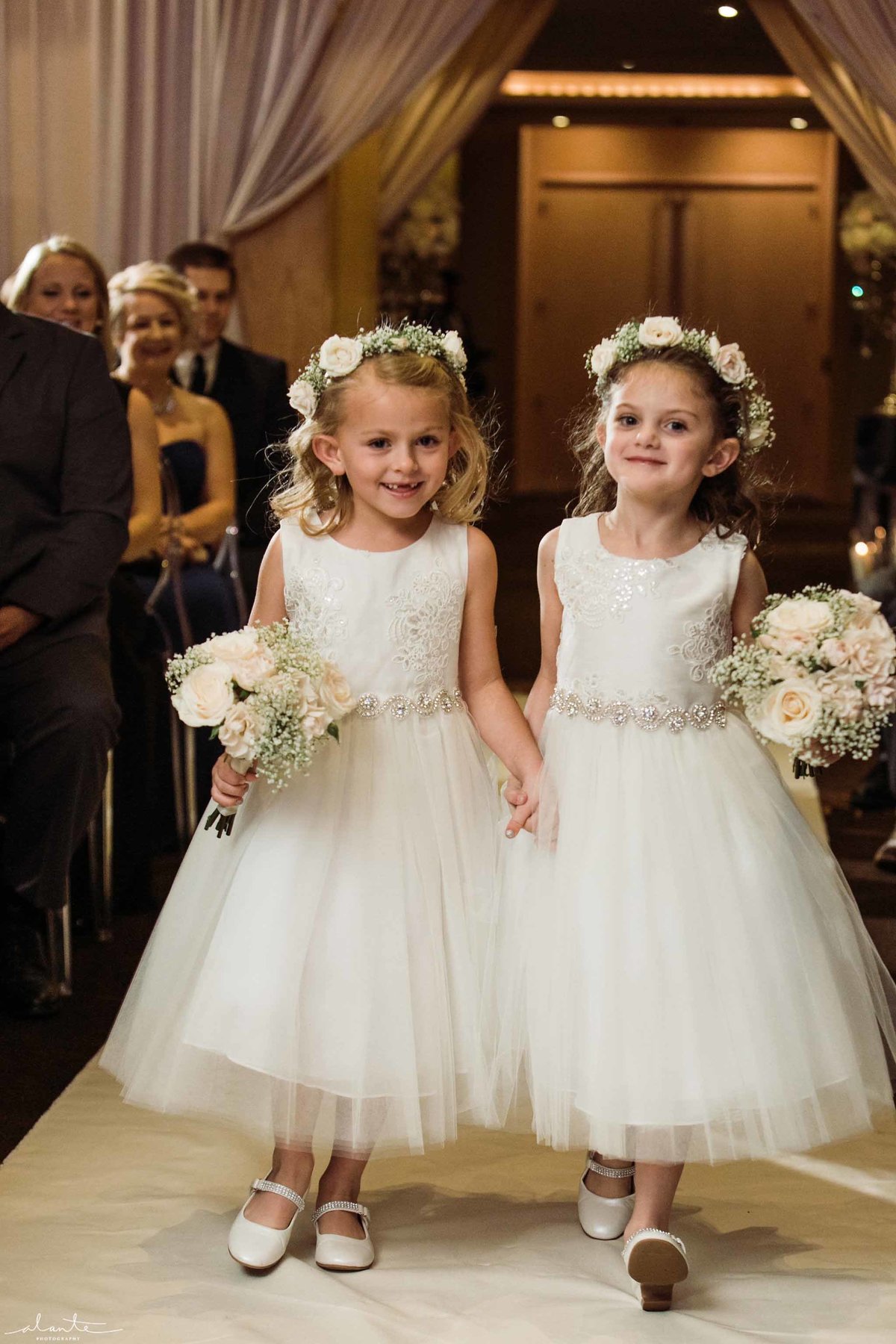 Darling flower girls with white flower crowns and small floral posies.