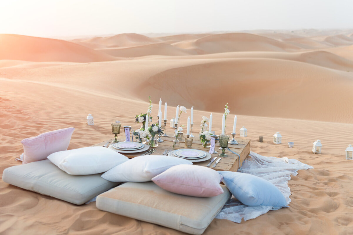 Sweetheart picnic table amidst the Arabian desert dunes, photoshoot organized by Lovely & Planned
