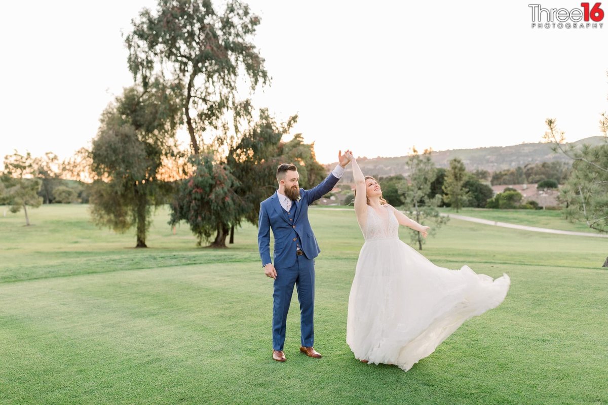 Groom twirls his Bride on the golf course greens